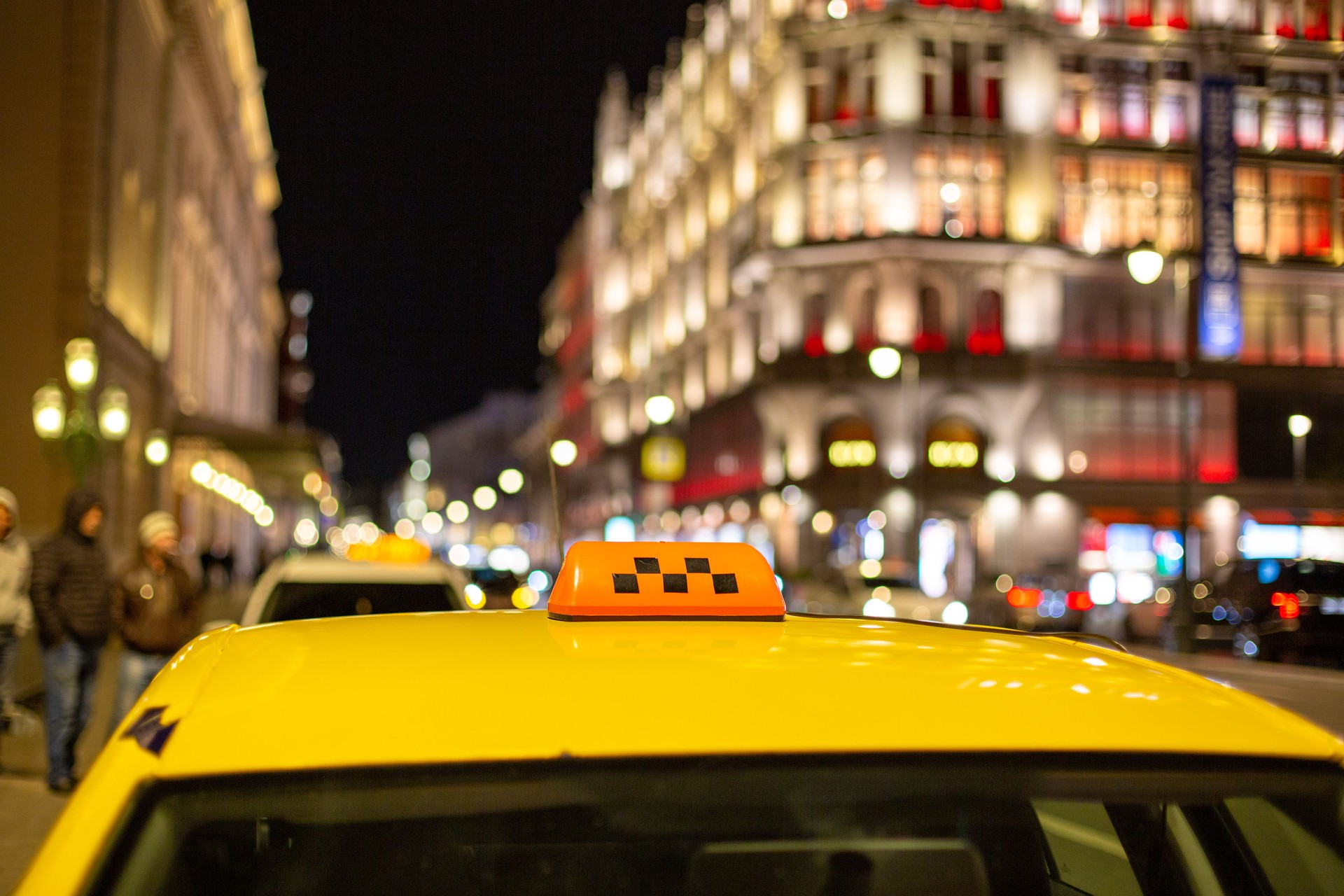 The big taxi sign on the background of night city